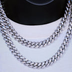 Close-up of two iced out Cuban link chains on a white shirt, hip hop jewelry - Miles Jewellery