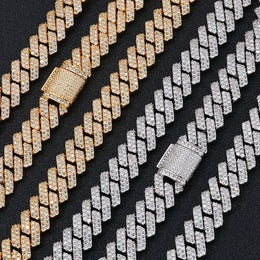 Gold and silver iced out Cuban link chains with diamond clasps on black background - Miles Jewellery