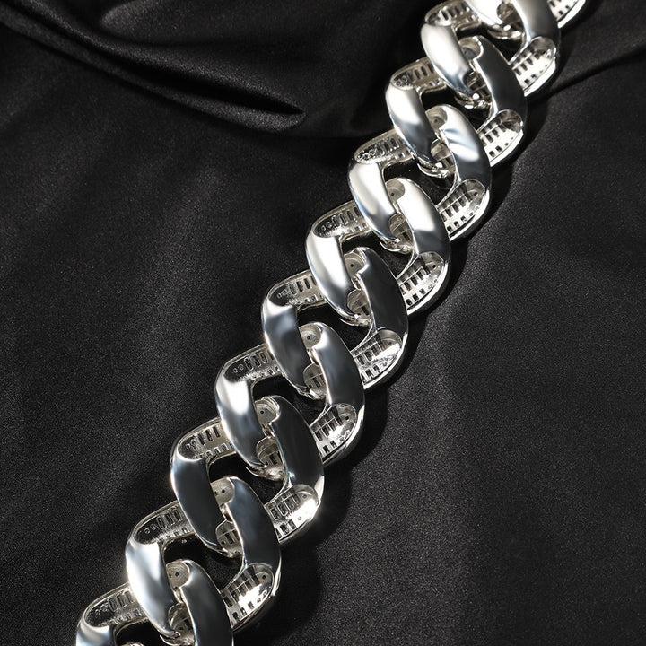 Smooth undersides of silver-tone Cuban links on black fabric