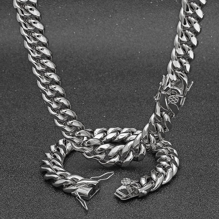 Silver-tone Cuban link necklace draped on a dark display with its clasp visible