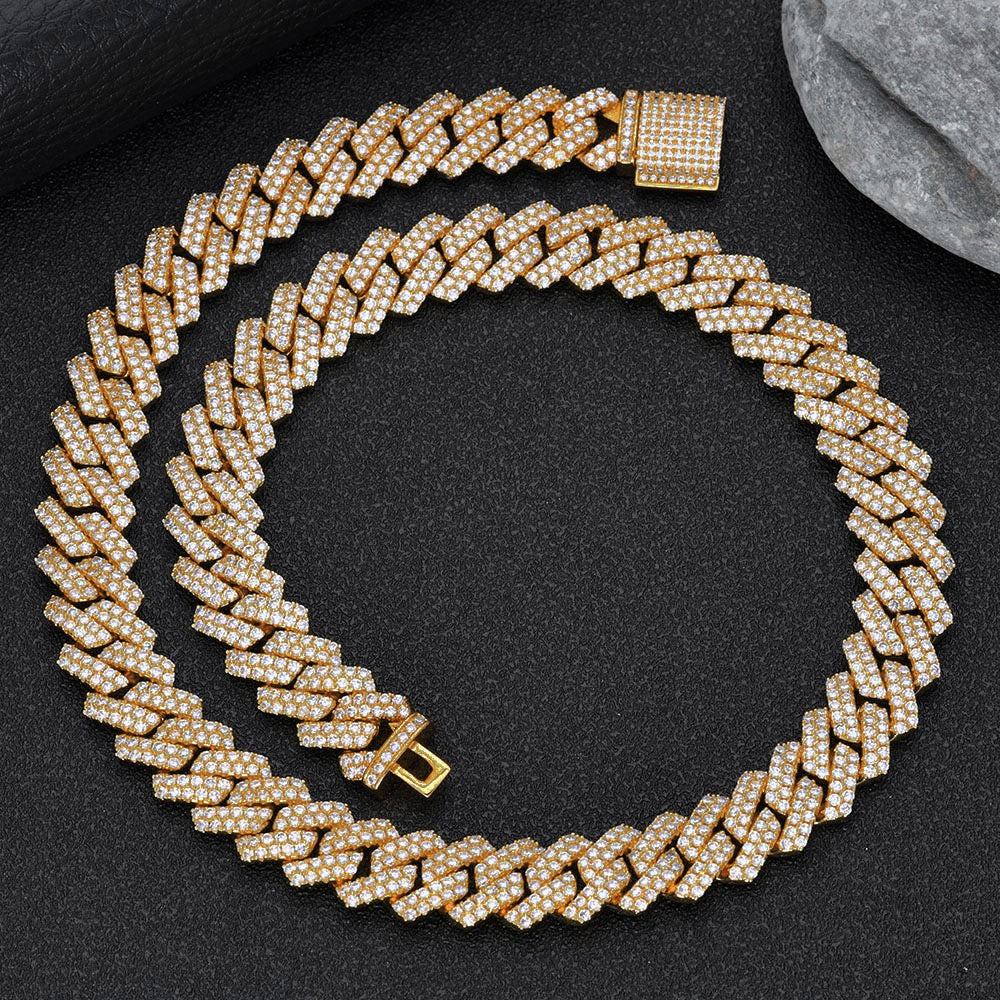 Gold Cuban link chain encrusted with sparkling stones on black surface - Miles Jewellery