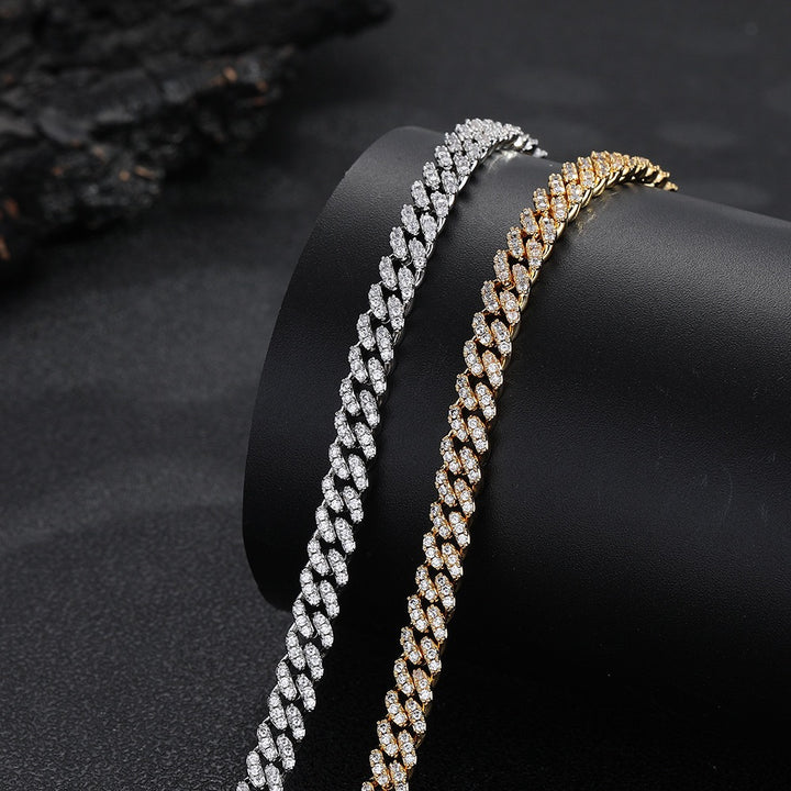 Silver-tone and gold-tone stone-set Cuban link chains on a black display