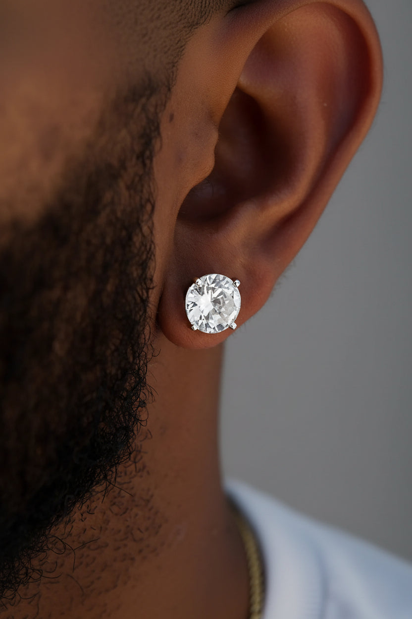Close-up of a diamond earring on an ear with a dark background