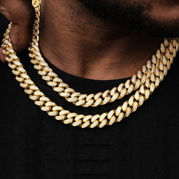 Close-up of gold iced out Cuban link chains with diamonds on a person's neck - Miles Jewellery