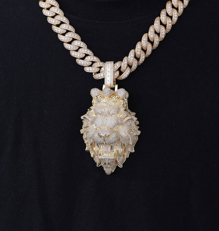 Gold-tone stone-set lion head pendant hanging from a Cuban link chain