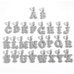 Silver-tone stone-set alphabet pendants arranged in rows on white