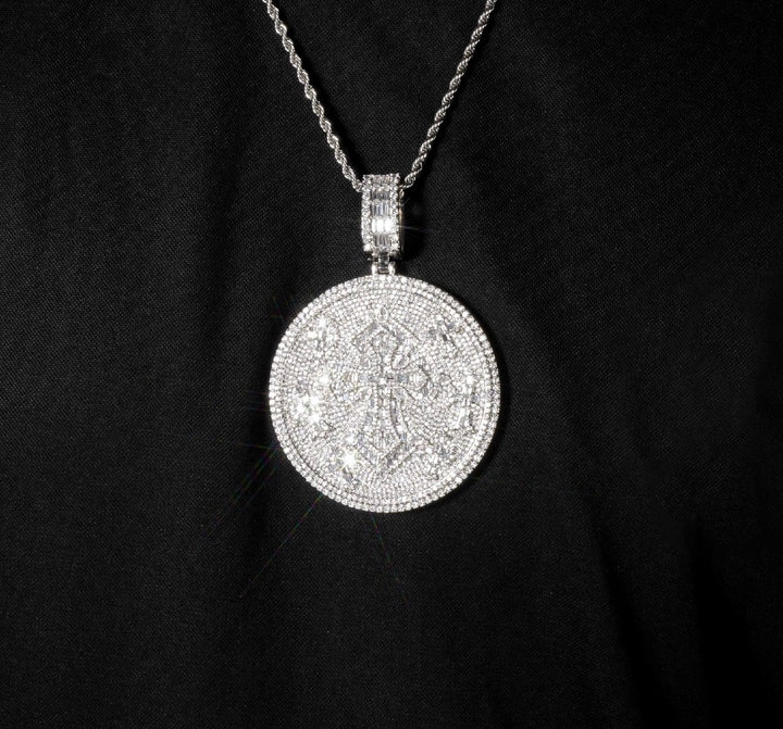 Round silver-tone cross medallion worn on a chain against black