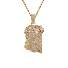 A gold Jesus head pendant necklace paved with clear cubic zirconia stones, featuring a detailed crown of thorns and a rope chain, shown on a solid white background.
