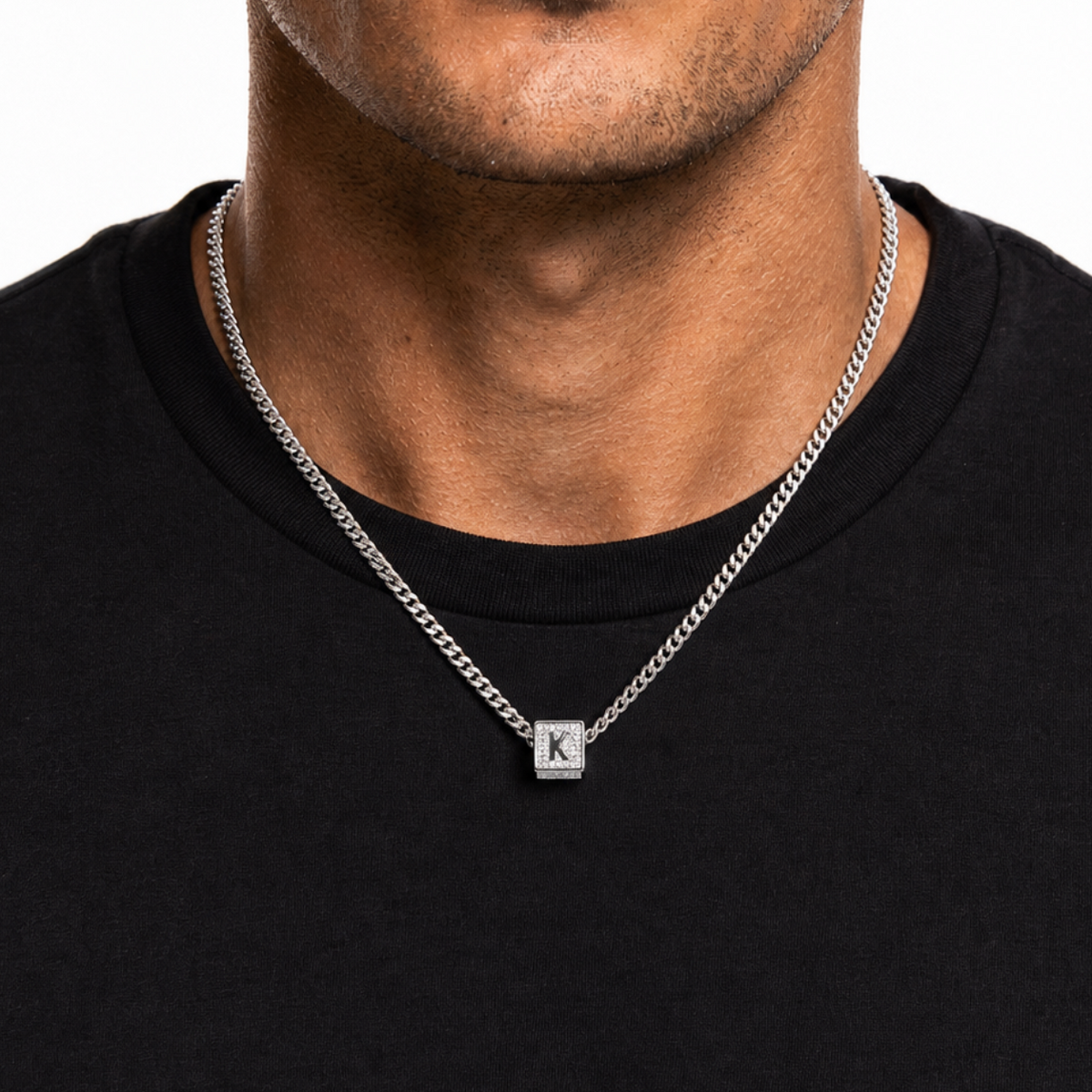Silver letter K alphabet block pendant necklace on black shirt