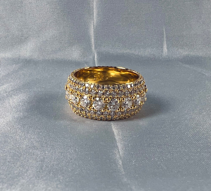 Wide gold-tone band ring set with rows of clear stones