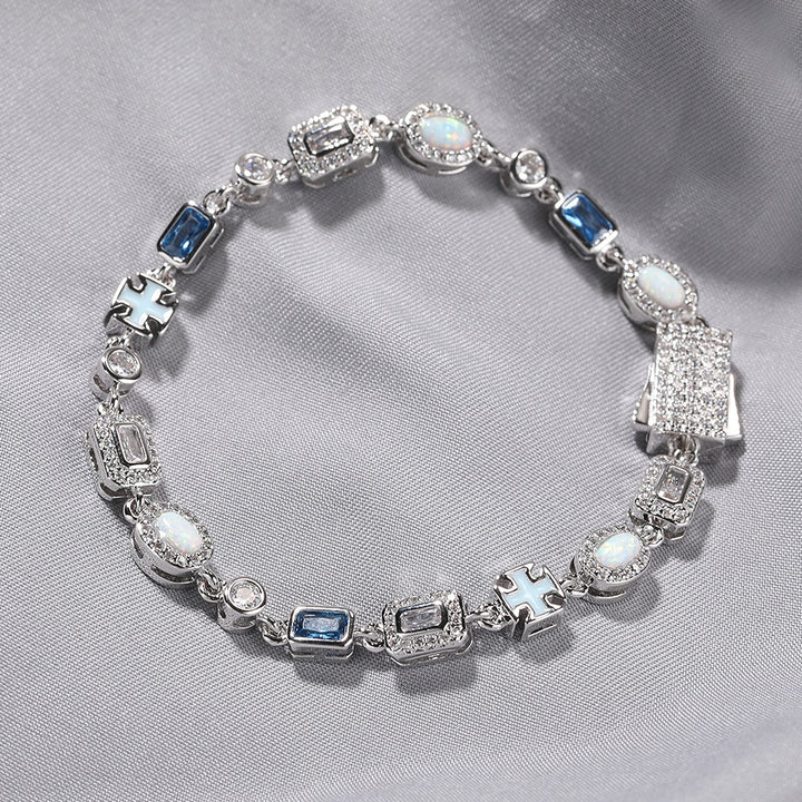 Silver-tone bracelet with blue and clear stones arranged on pale fabric
