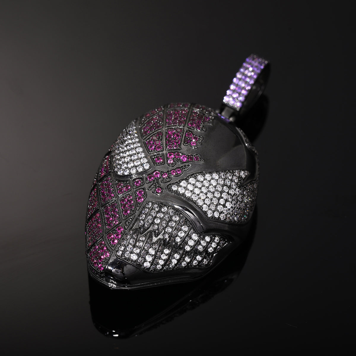 Angled close-up of the fanged mask pendant showing clear stone eyes, teeth and pink stone detailing
