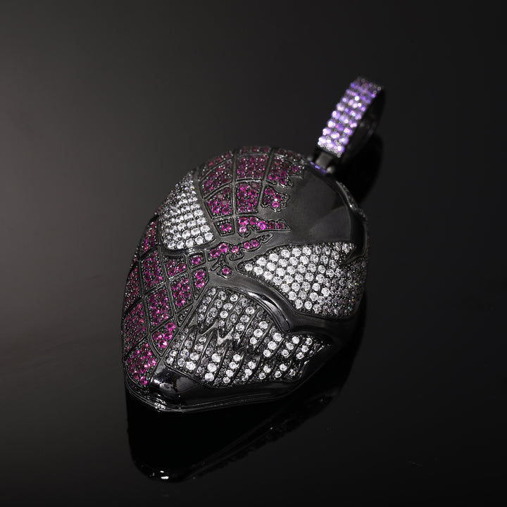 Angled close-up of the fanged mask pendant showing clear stone eyes, teeth and pink stone detailing