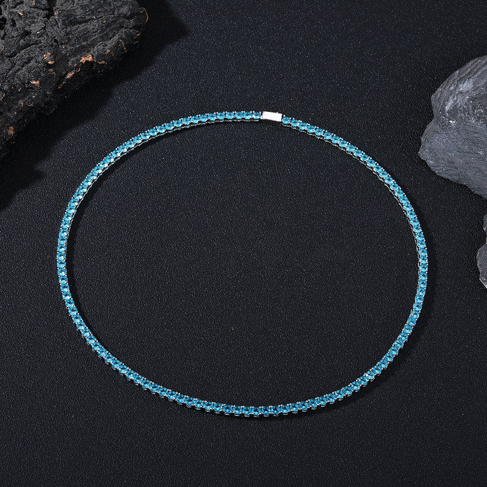 Dark-background detail view of 4mm iced aqua blue CZ tennis chain necklace