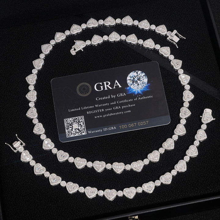 Silver-tone heart-link tennis necklace coiled beside GRA paperwork