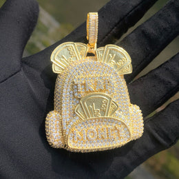 Gold-tone backpack pendant with stone-set pockets and banknote motifs