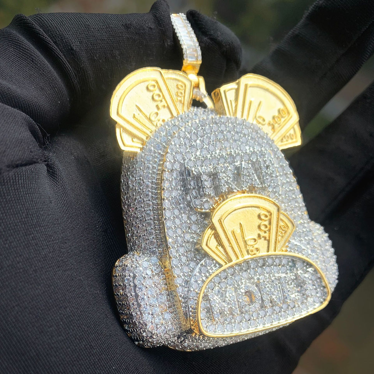 Angled view of the two-tone backpack pendant showing pocket depth