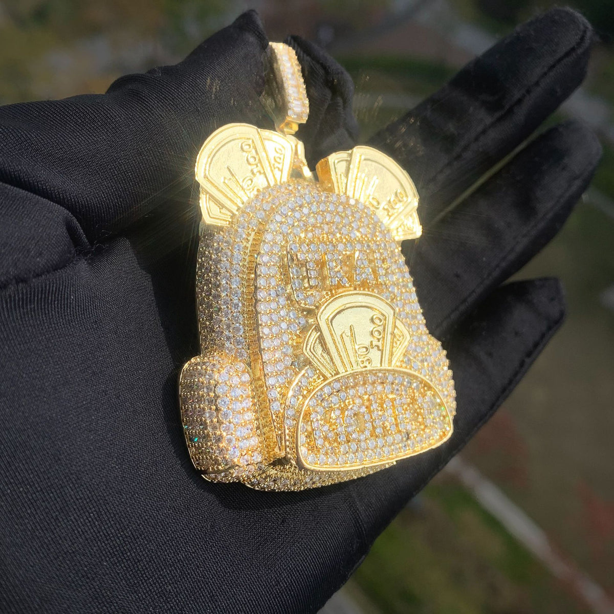 Angled gold-tone backpack pendant with raised front and side pockets