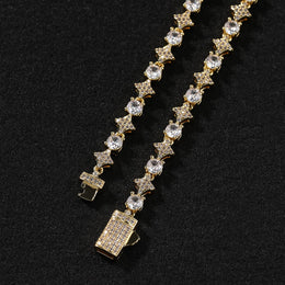 Gold 6mm iced star tennis chain clasp detail on a black background