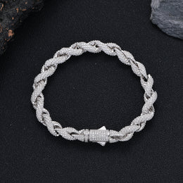 Rope bracelet arranged in a circle on a dark surface with its clasp closed