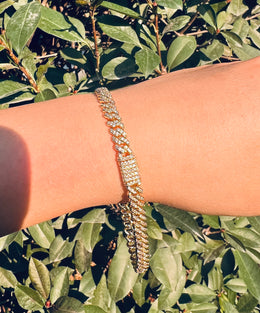 Gold iced out tennis chain bracelet with diamonds on wrist outdoors - Miles Jewellery