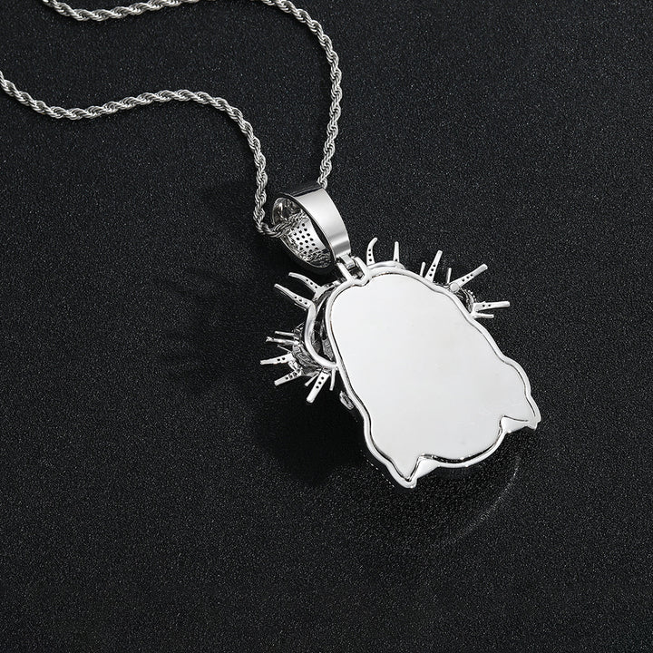 Smooth back of a silver-tone Jesus head pendant and thorn crown