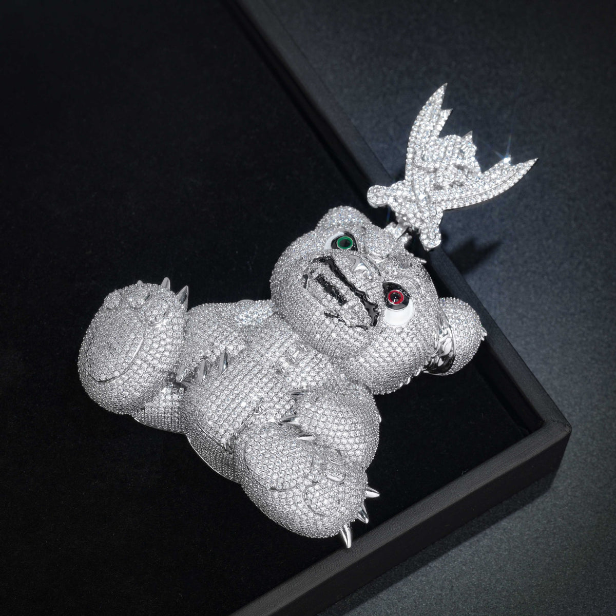 Angled view of the spiked bear pendant resting in a black display box