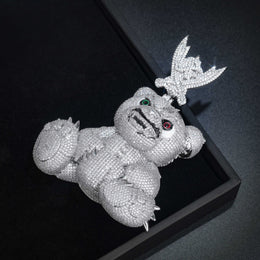 Angled view of the spiked bear pendant resting in a black display box