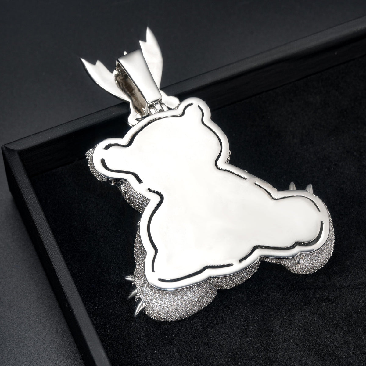 Polished back of the bear pendant showing its outline and the rear of the bail