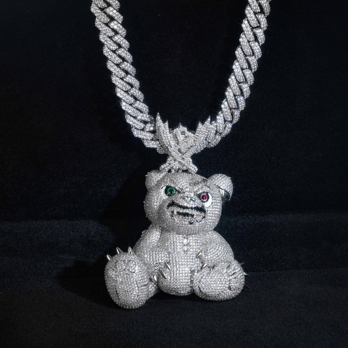Front view of the silver-tone bear pendant hanging against a black background