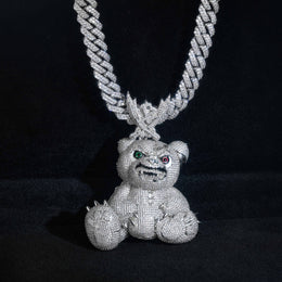 Front view of the silver-tone bear pendant hanging against a black background