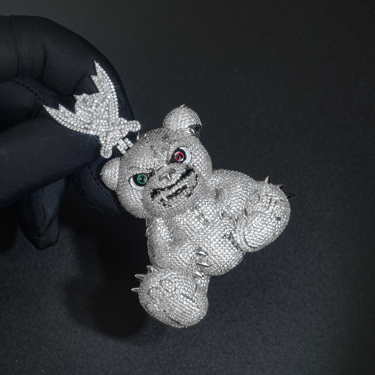 Gloved hand holding the pavé bear pendant by its ornate bail