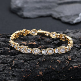 Gold-tone geometric halo bracelet resting on dark stone