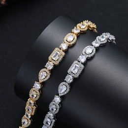 Silver-tone and gold-tone geometric bracelets draped over a black display