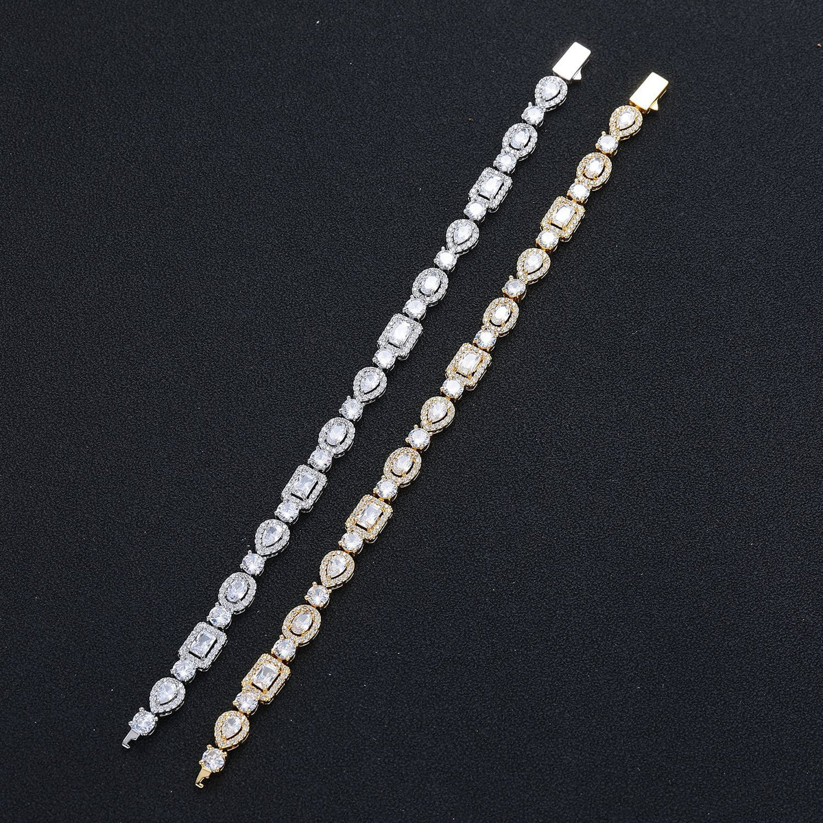 Silver-tone and gold-tone geometric bracelets laid straight on black fabric