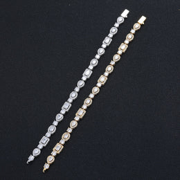 Silver-tone and gold-tone geometric bracelets laid straight on black fabric