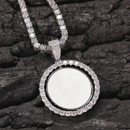 Silver-tone photo pendant with a white photo area resting on dark textured wood