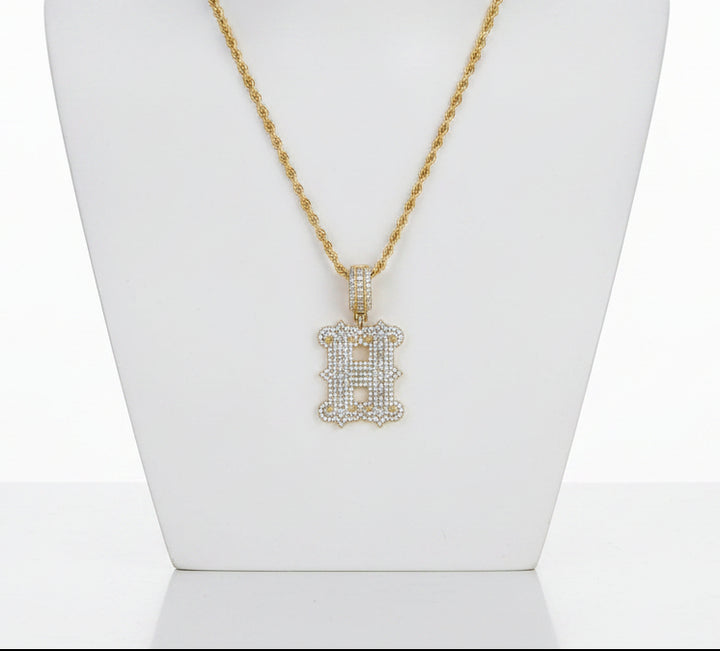 Stone-set gold-tone letter H pendant on a rope chain displayed on a white necklace bust
