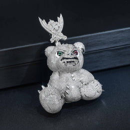 Silver-tone pavé bear pendant resting upright on a dark surface