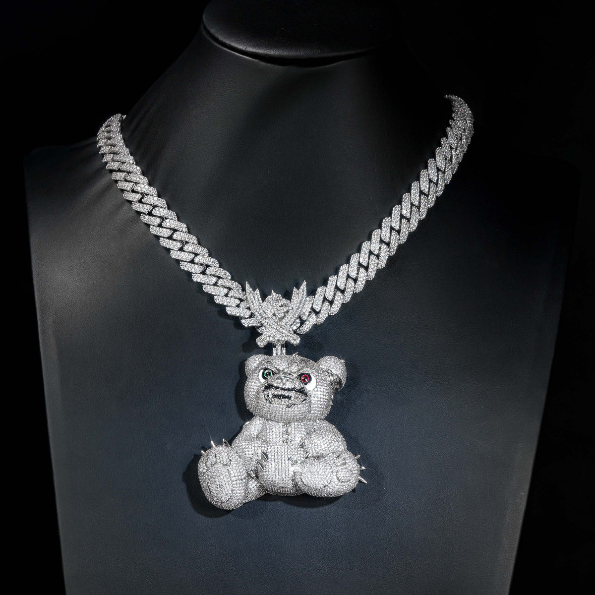 Silver-tone bear pendant displayed on a black jewelry bust