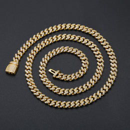 Gold-tone moissanite Cuban chain arranged in a wide spiral on black