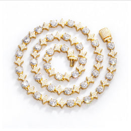 Gold-tone moissanite necklace with alternating star links and round stones, coiled on white