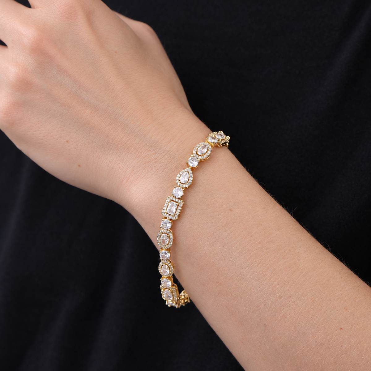 Model wearing a gold-tone geometric halo bracelet with a black shirt