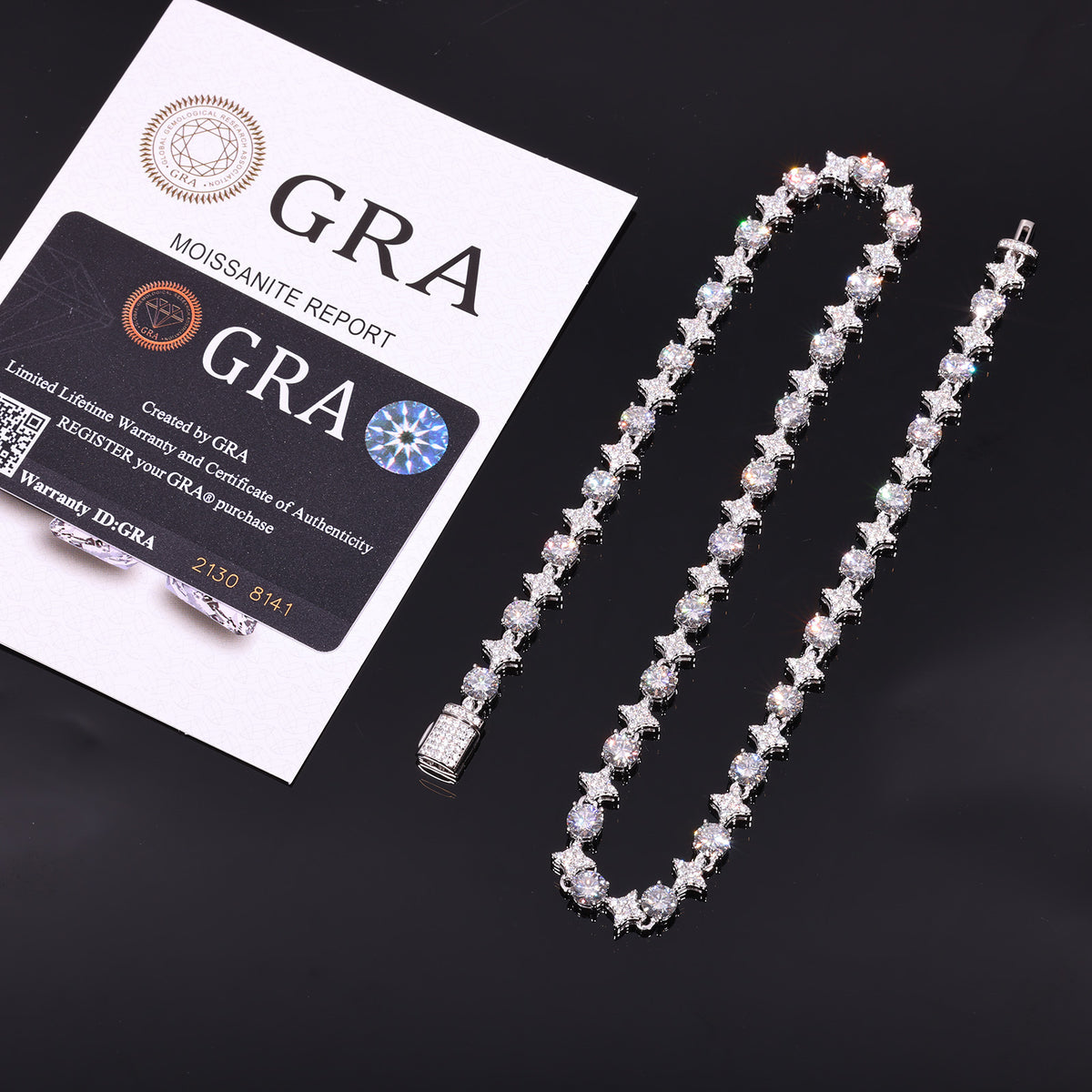Silver-tone moissanite star tennis necklace beside GRA report papers and a card