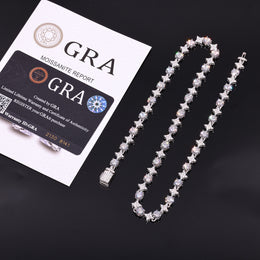 Silver-tone moissanite star tennis necklace beside GRA report papers and a card