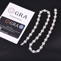 Silver-tone moissanite halo tennis chain beside GRA report papers and a card on black