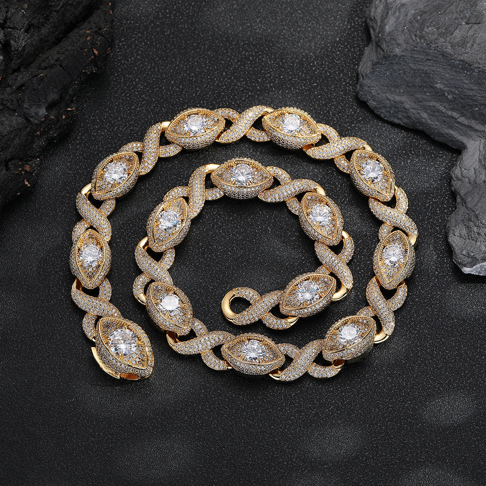 Gold-tone infinity eye-link necklace coiled on a black surface