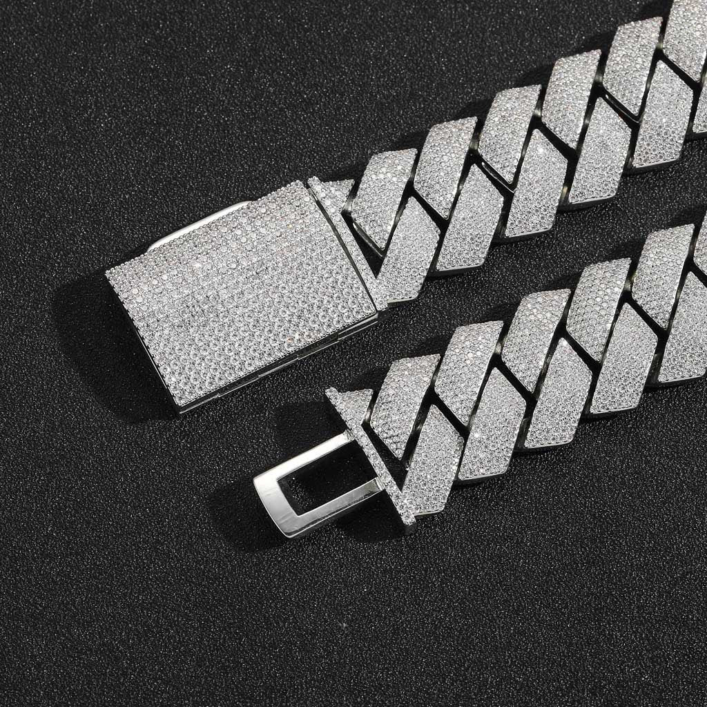 Silver-tone pavé box clasp with its tongue open on black fabric