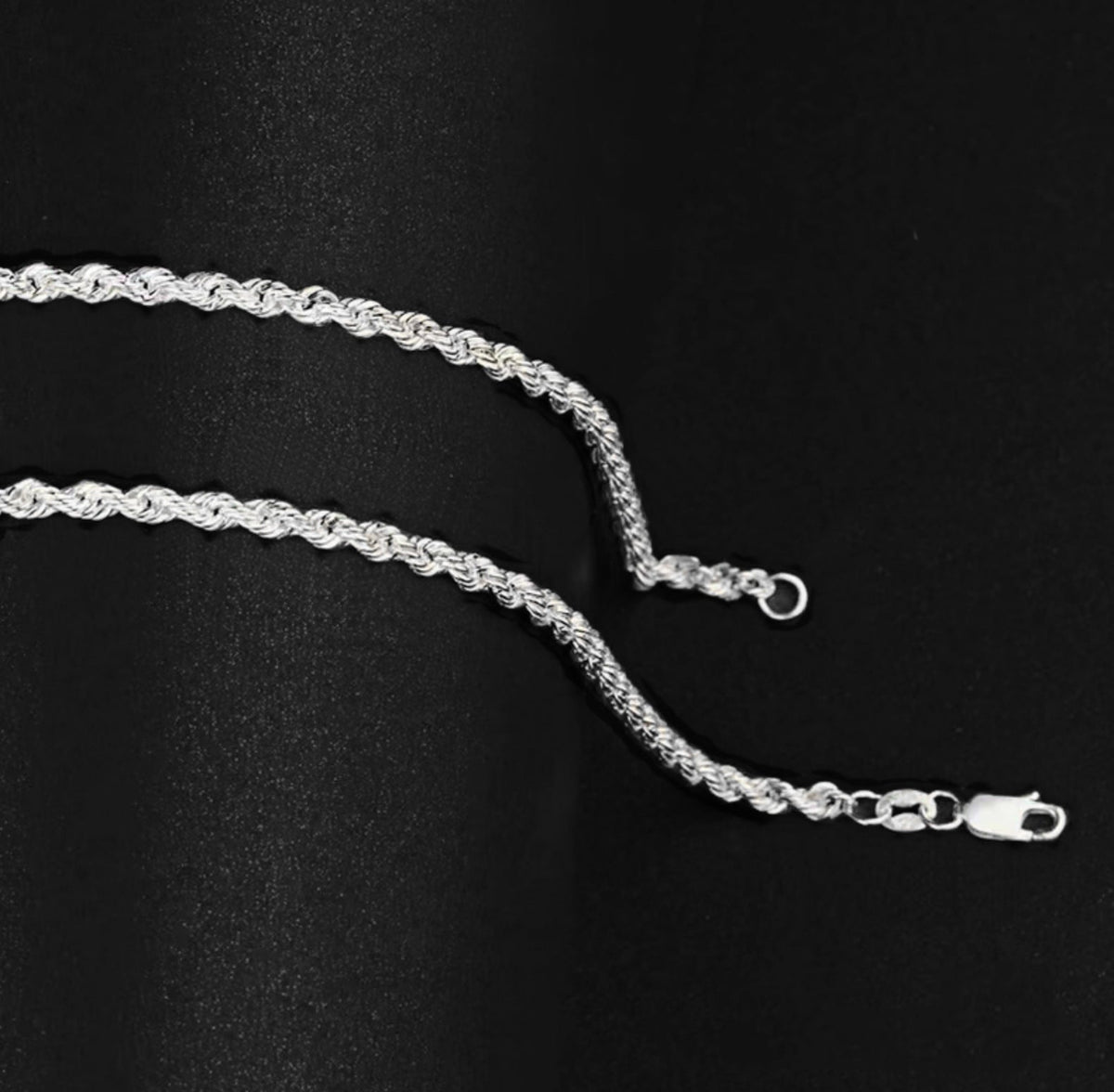 Silver-tone rope chain links with a lobster clasp on black