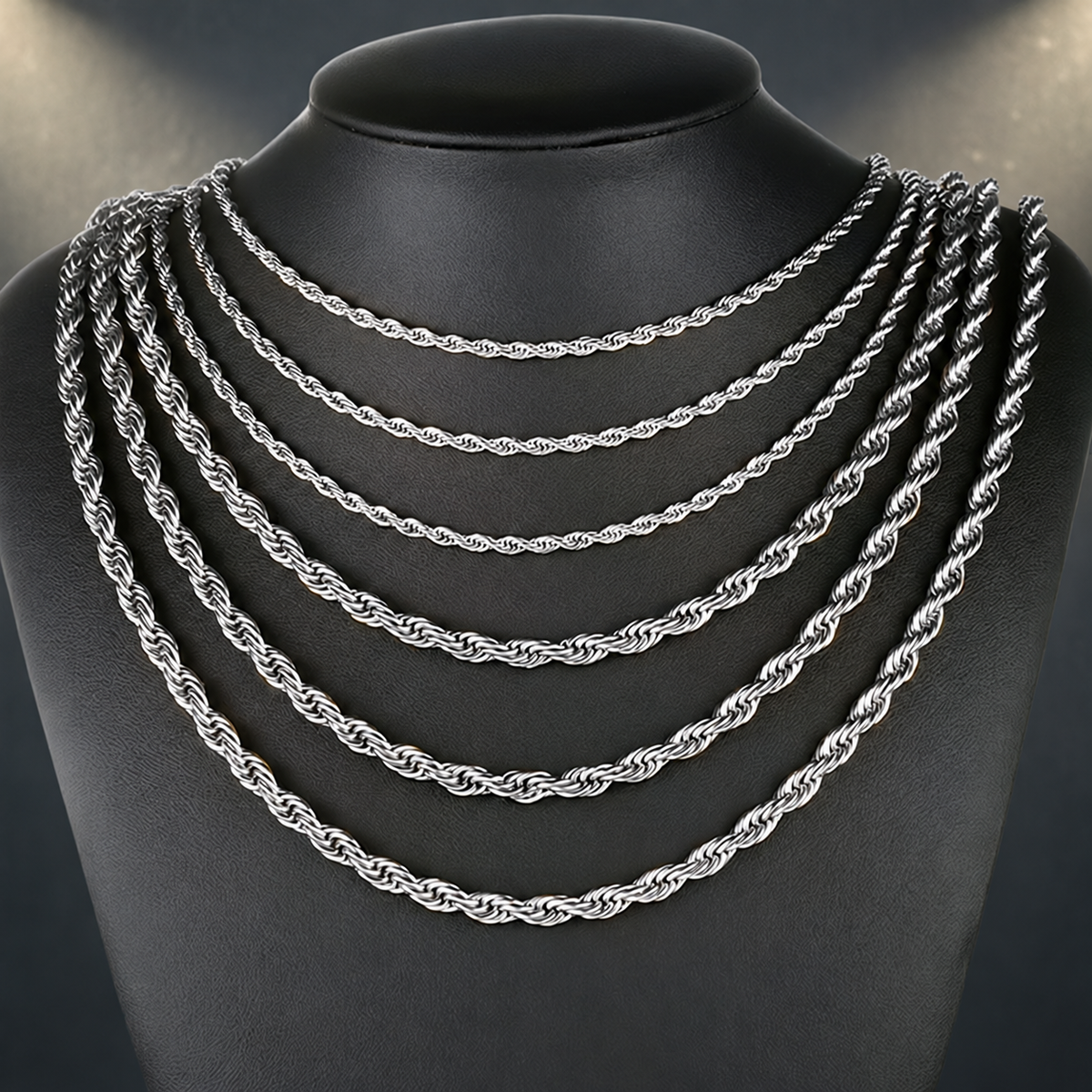 Six silver-tone rope chains in graduated widths on a black display bust